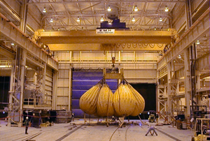 This 200/50 ton radio-controlled crane loads turbines onto rail cars for shipment. Crane has a span of 75 feet, a lift of 40 feet, and uses two EMH engineered hoists